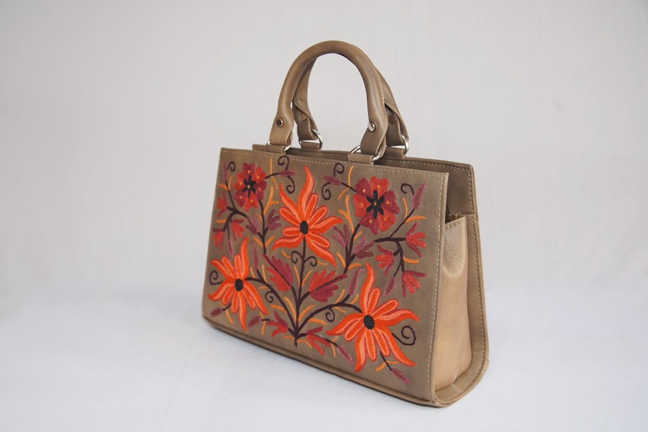 services-02 Stylish handbag with vibrant floral embroidery on a white background, perfect for fashion shoots.